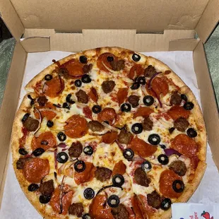 Sausage, pepperoni, olives and red onion pizza