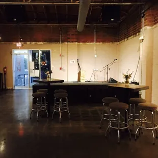 a large room with a bar and stools