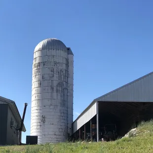 a silo and a barn on a hill