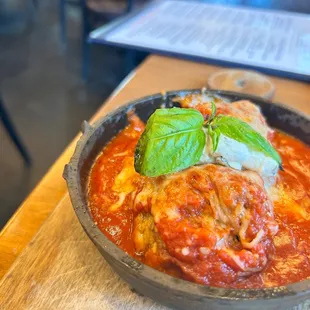 a bowl of pasta with meat and basil