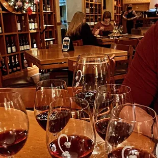 a man sitting at a table with wine glasses