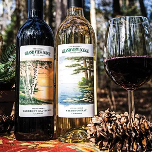 two bottles of wine and a glass of wine