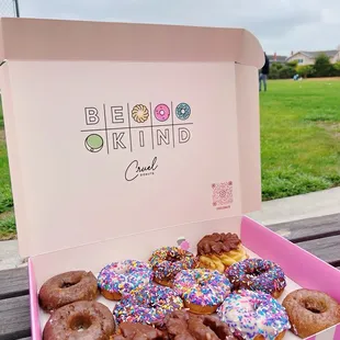 a box of donuts on a park bench