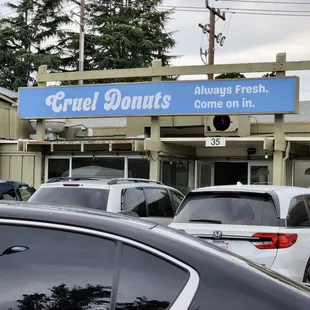 cars parked in front of a donut shop