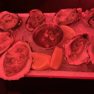 a platter of oysters with a side of dipping sauce