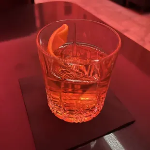 a drink in a glass with a slice of orange