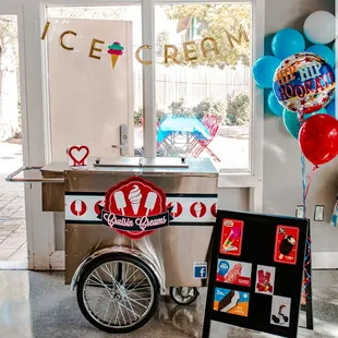 an ice cream cart with balloons