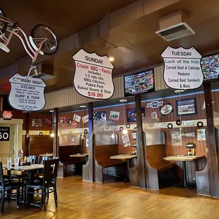 a restaurant with tables, chairs, and a bicycle hanging from the ceiling