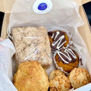 a person holding a box of pastries