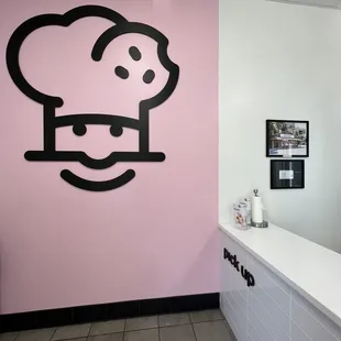 a chef&apos;s face on a pink wall