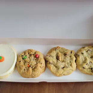 Frosted sugar cookie with pumpkin candy, monster, and two milk chocolate chip cookies
