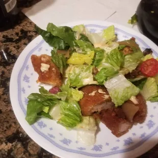 a plate of salad with bacon and lettuce