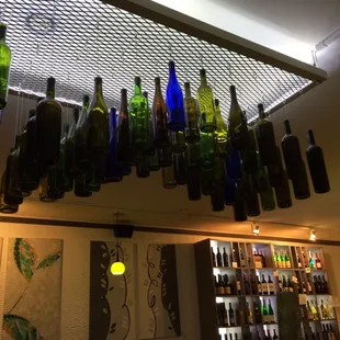 a bunch of wine bottles hanging from the ceiling