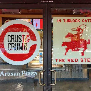 a red steer and a sign that says the red steer