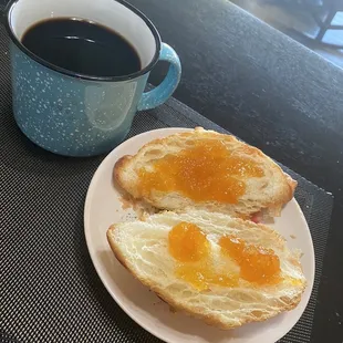 A delicately flaky croissant with apricot preserves and a cup of coffee for Sunday breakfast.