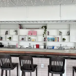 a kitchen with white cabinets and black bar stools
