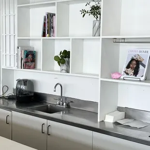 a kitchen with a sink and shelves