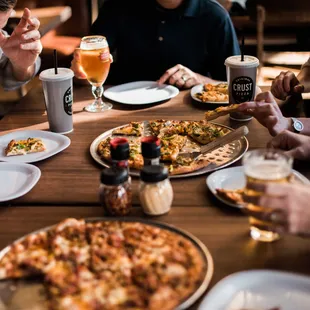 people eating pizza and drinking beer