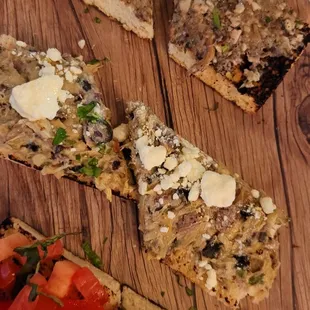 four slices of pizza on a wooden cutting board