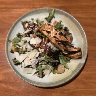 a plate of salad on a wooden table