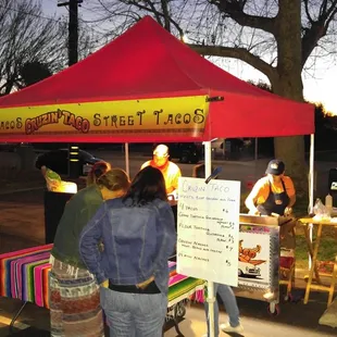  group of people standing under a tent