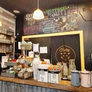 a coffee shop counter with a menu on the wall