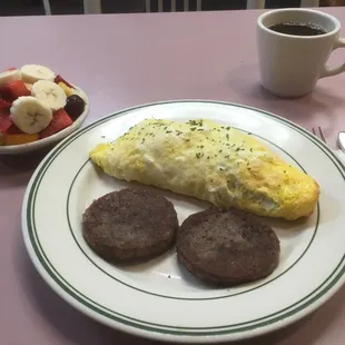 Steak and Swiss omelet, side of sausage patties and fruit.