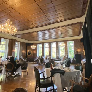 people sitting at tables with chandeliers