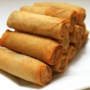 a stack of fried spring rolls on a white plate
