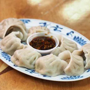 a plate of dumplings with dipping sauce