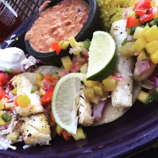 Pan-seared fish tacos with mango salsa, saffron rice and beans.