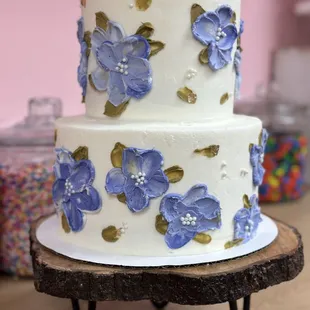 a three tiered cake with blue flowers