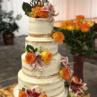 a three - tiered wedding cake with fresh flowers