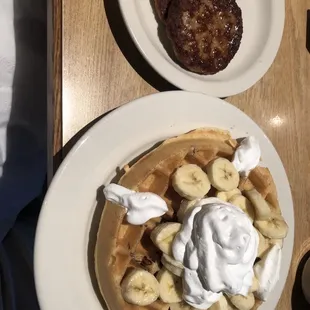 Banana and pecan waffle with a side of sausage.