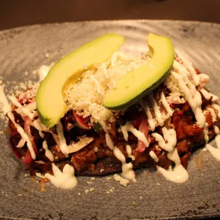 Huarache - Blue corn tortilla flatbread, layered with refried beans, your choice of filling, Mexican slaw, crema, queso fresco, and avocado