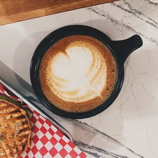 Latte and bagel sandwich with avocado by Emily