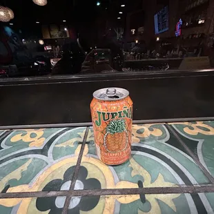 a can of soda on a tiled floor