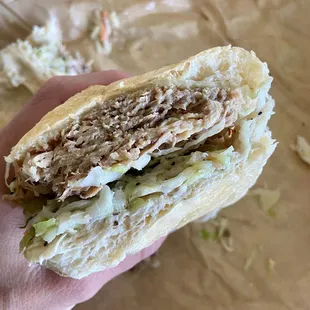 a hand holding a sandwich