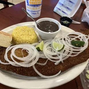 Bistec Empanizado, yellow rice, and black beans