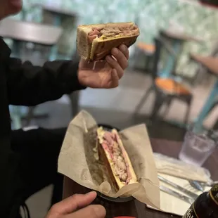 a person holding a sandwich in their hand