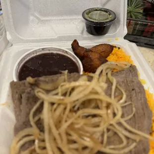 Chimichurri Steak with Grilled Onions with black beans, yellow rice, and plantains.