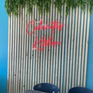 a table and chairs in front of a blue wall