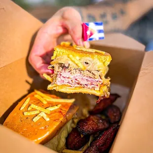 a hand holding a sandwich