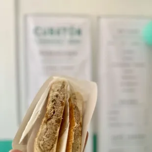 a hand holding a sandwich