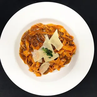 a plate of pasta with meat and parmesan cheese