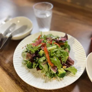 a plate of salad and a glass of water