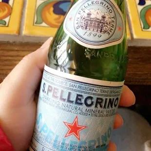 a person holding a bottle of heineberg