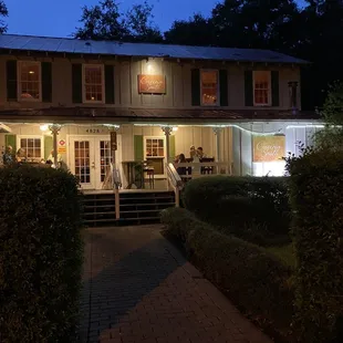 Dreamy night time entrance with outdoor seating.