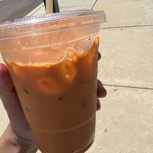 a hand holding a cup of iced coffee