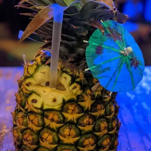 a pineapple with a blue umbrella